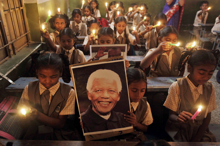 Schoolchildren hold candles and portrait of former South African President Nelson Mandela as they pay tribute to him on hearing of his death, at a school in Ahmadabad, India, Friday. (AP Photo/Ajit Solanki)