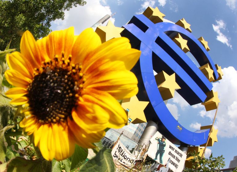 FILE - The July 5, 2012 file photo shows a sunflower sitting in front of the Euro sculpture in Frankfurt, Germany. A closely-watched survey has found business activity across the 18-country eurozone running at a three-year high, in perhaps the clearest sign yet that the economic recovery is gaining momentum. Analysts said Wednesday's, April 23, 2014 positive data could take some of the pressure off the European Central Bank to take further steps to stimulate the economy at its next monthly policy meeting on May 8 despite stubbornly low inflation across the 18-country single currency zone.  (AP Photo/Michael Probst, file)