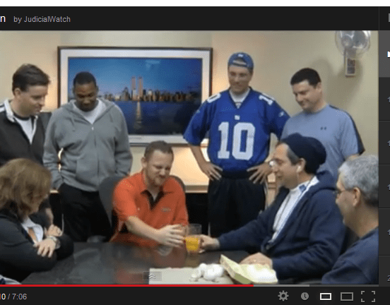 An employee of the General Services Administration's Public Buildings Service prepares to down a raw-egg cocktail like Rocky Balboa as co-workers look on and Bill Conti's iconic 