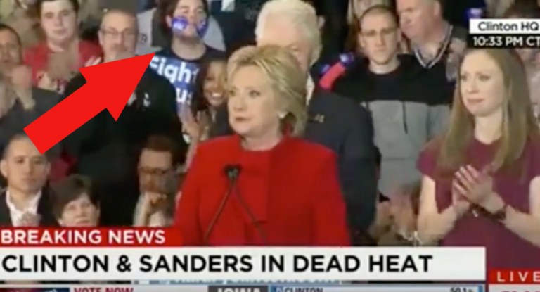 Watch A Man Eat Hillary Sticker Behind Her At Post-Iowa Caucus Speech
