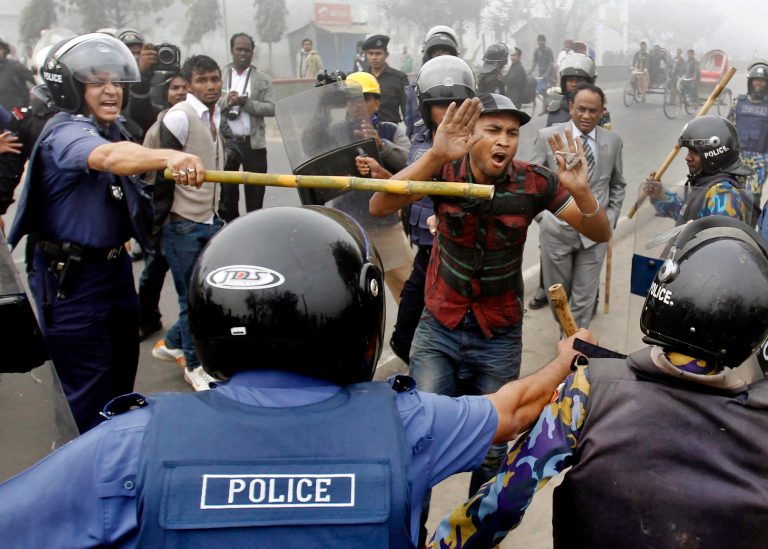   Police officials wield bamboo sticks to stop main opposition Bangladesh Nationalist Party activist during a protest in Kachpur, on the outskirts of Dhaka, Bangladesh, Sunday, Dec. 9, 2012. Police fired rubber bullets and tear gas Sunday to disperse stone-throwing protesters who set fire to vehicles and tried to block roads across Bangladesh to demand restoration of caretaker administration to oversee upcoming national elections. (AP Photo/A.M. Ahad)  