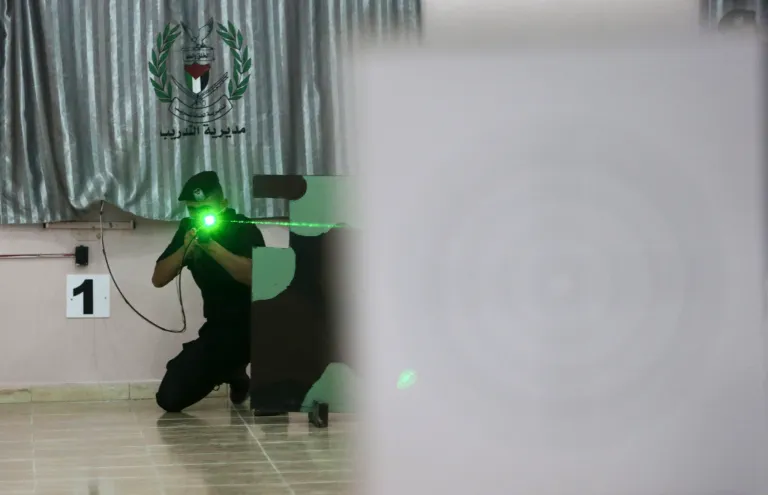 Palestinian security officer Muhmmad Debo, 22, practices with an electronically-modified AK-47 rifle at the headquarters of the security training department of the Hamas interior ministry in Gaza City, in the northern Gaza Strip on Thursday, April 10, 2014. The laser-fitted rifles are a money saver that eliminates the need to train with live ammunition, which is in short supply in Gaza. (AP Photo/Adel Hana)