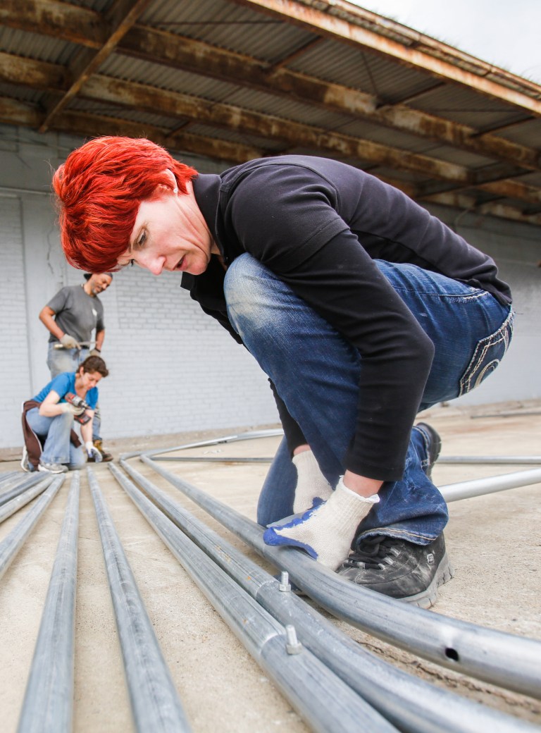In this April 18, 2014 photo, farm manager Michelle Lutz helps put together poles for a high-tunnel greenhouse , as part of the RecoveryPark project, used to grow various herbs and vegetables to sell commercially to the community in Detroit. RecoveryPark is the work of Self-Help Addiction Rehabilitation Inc., which specializes in substance abuse treatment. (AP Photo/Detroit Free Press, Jarrad Henderson)  DETROIT NEWS OUT;  NO SALES