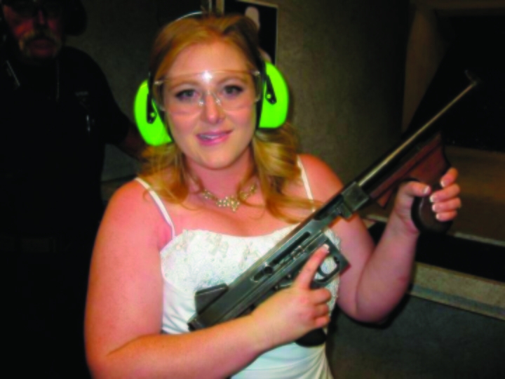 This July 28, 2012 photo provided by Bob MacDuff shows Lindsae MacDuff holding an automatic weapon at the Gun store in Las Vegas after her 