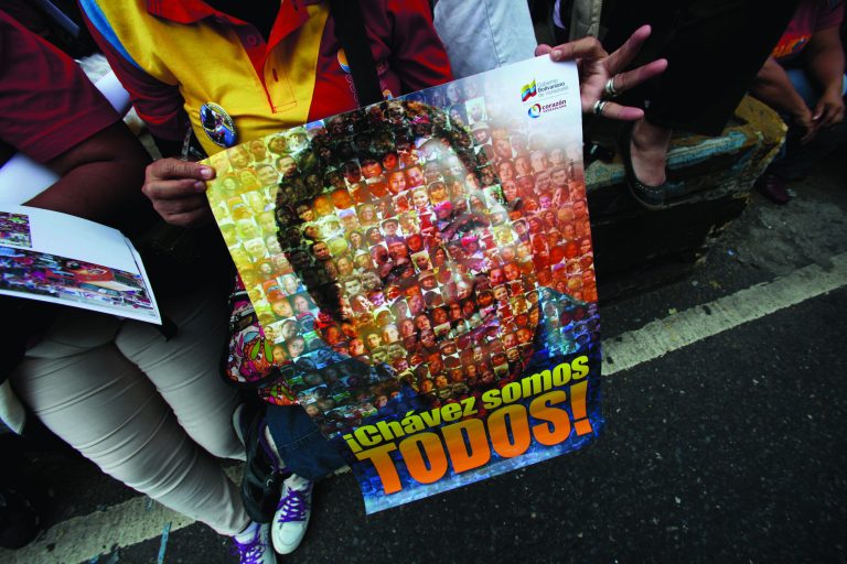 A supporter of Venezuela's President Hugo Chavez holds poster of him with the slogan in Spanish 