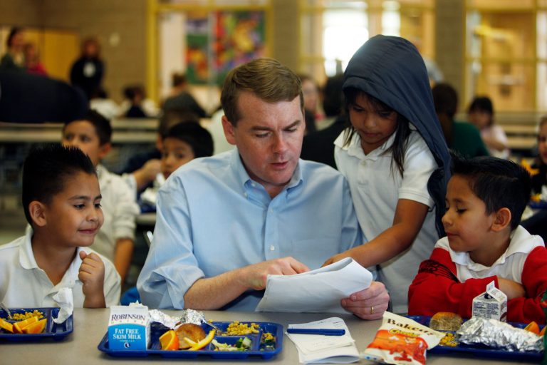 U.S. Sen. Michael Bennet, D-Colo., second from left, looks over a paper with 7-year-old Teresa Ruiz, third from left, as Bennet shares lunch with 7-year-old Sigifredo Orona, left, and 8-year-old Michael Zamarano during an appearance at Coronado Hills Elementary School in the north Denver suburb of Thornton, Colo., on Tuesday, April 6, 2010. (AP Photo/David Zalubowski)