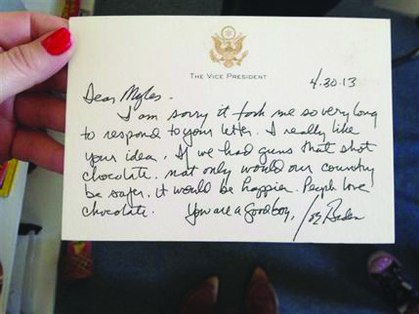 In this photo provided by Downtown Montessori Academy teacher Jenny Aicher, Aicher holds a note, Monday, May 13, 2013, in Milwaukee, written by Vice President Joe Biden to Myles, a 7-year-old second-grader at the school. The school did not release Myles' last name. Myles wrote Biden with an unusual suggestion for making the nation safer: Create guns that shoot chocolate bullets. On Monday, he received Biden's response, which created a buzz at the school. (AP Photo/Jenny Aicher)