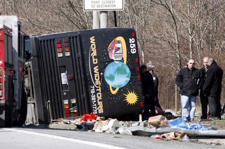   FILE - In this March 12, 2011, file photo, emergency personnel investigate the scene of a bus crash on Interstate 95 in the Bronx borough of New York. Safety officials are planning to release Tuesday, June 5, 2012, the results of an investigation into a deadly tour bus crash in New York last year that killed 15 passengers and helped prompt a crackdown on rogue bus operators by federal regulators. (AP Photo/David Karp, File)  