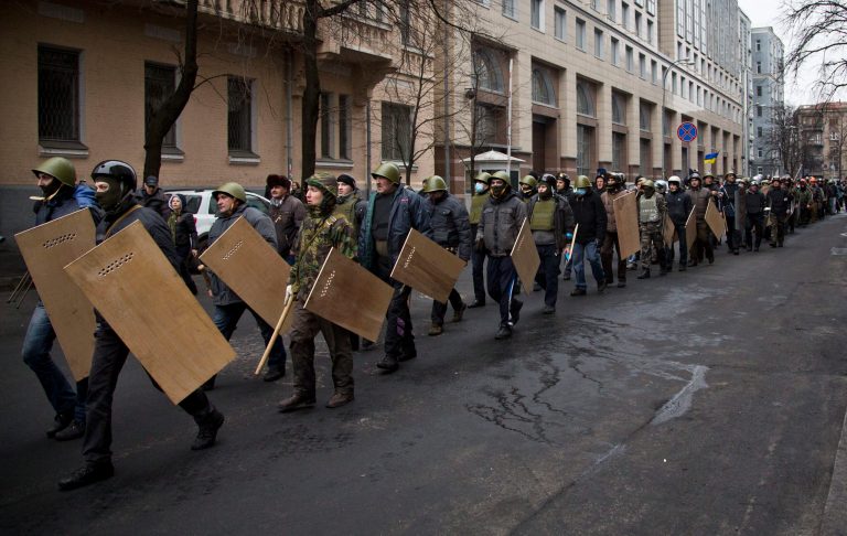 Protesters with shields and sticks move towards the parliament building in central Kiev, Ukraine, on Saturday. (AP/Darko Bandic)