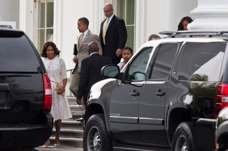 First lady Michelle Obama, left, walks with President Barack Obama, and daughters Sasha and Malia, both partially obscured, from the White House to a motorcade to attend Easter services on Sunday, April 20, 2014, in Washington. The first family attended services at the Nineteenth Street Baptist Church in Washington. (AP Photo/Jacquelyn Martin)
