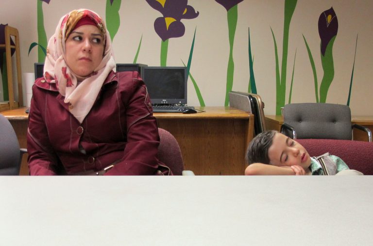 In this Friday, Sept. 2, 2016 photo, Syrian refugee Fatema, left, sits beside her sleeping 5-year-old son Ayham at the Integrated Refugee & Immigrant Services in New Haven, Conn. The family was diverted to Connecticut last year after Indiana Gov. Mike Pence said they were not welcome in that state. In their new home state, they have been received warmly by many, including Connecticut's Democratic governor, but they say they also have faced difficulties with finding work and with discrimination. (AP Photo/Pat Eaton-Robb)