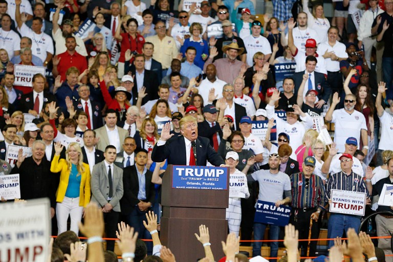 The majority of the crowd followed his instructions, lifting their hands upward while repeating his the pledge he dictated for them. (AP Photo/Brynn Anderson)
