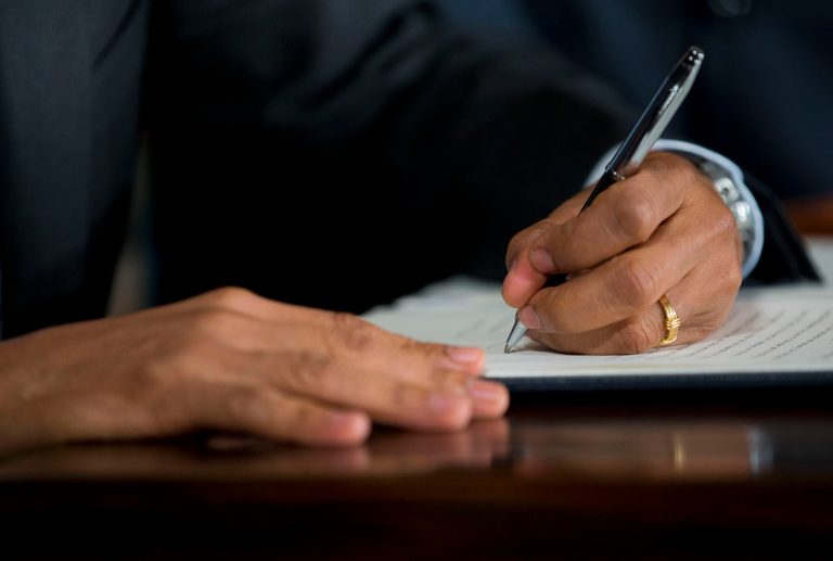 President Obama signs an executive order raising the minimum wage for federal contract workers on Wednesday during a ceremony in the East Room of the White House in Washington. (AP Photo/Pablo Martinez Monsivais)