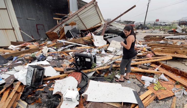Jennifer Bryant looks over the debris from her family business destroyed by Hurricane Harvey Saturday, Aug. 26, 2017, in Katy, Texas. Harvey rolled over the Texas Gulf Coast on Saturday, smashing homes and businesses and lashing the shore with wind and rain so intense that drivers were forced off the road because they could not see in front of them. (AP Photo/David J. Phillip)