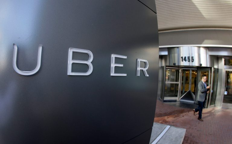 In this Dec. 16, 2014, file photo a man leaves the headquarters of Uber in San Francisco. (AP Photo/Eric Risberg, File)