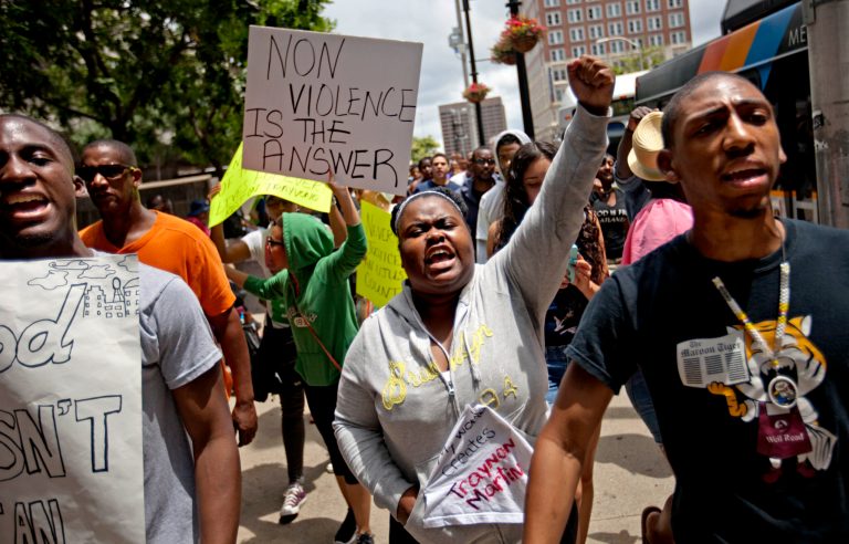 Lisa Archer, 24, of Atlanta, center, chants as protestors march, Sunday, July 14, 2013, in Atlanta the day after George Zimmerman was found not guilty in the 2012 shooting death of teenager Trayvon Martin.  From New York to California, outrage over the acquittal in George Zimmerman's murder trial poured from street demonstrations and church pulpits. (AP Photo/David Goldman)
