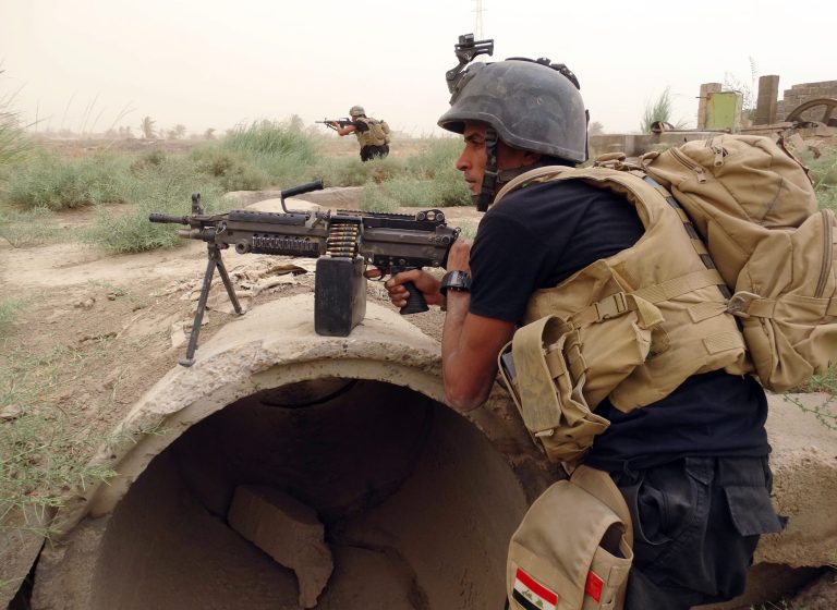 Iraq's Special Weapons and Tactics Team with U.S.-made weapons, prepare to attack Islamic State Group militants at the front line in Iraq. (AP Photo)
