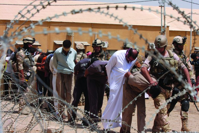 FILE - In this file photo taken on Friday, July 20, 2012, blindfolded and handcuffed suspected al-Qaida members are led away to detention centers in an Iraqi army base in Hillah, about 60 miles (95 kilometers) south of Baghdad, Iraq. Al-Qaida is slowly resurging in Iraq, and has set up training camps for insurgents in the nation's western deserts as the extremist group seizes on regional instability and government security failures to regain strength, officials say. (AP Photo/Alaa al-Marjani File)