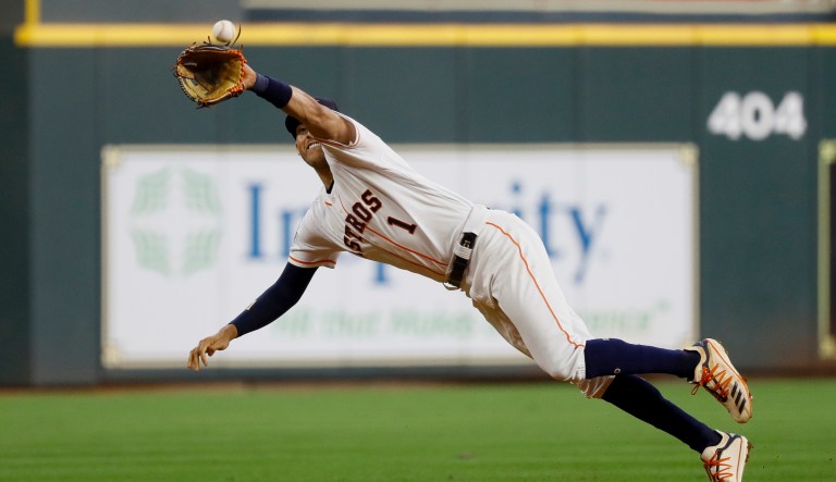 Houston Astros shortstop Carlos Correa catches a line drive by Washington Nationals' Howie Kendrick during the fourth inning of Game 1 of the baseball World Series Tuesday, Oct. 22, 2019, in Houston.