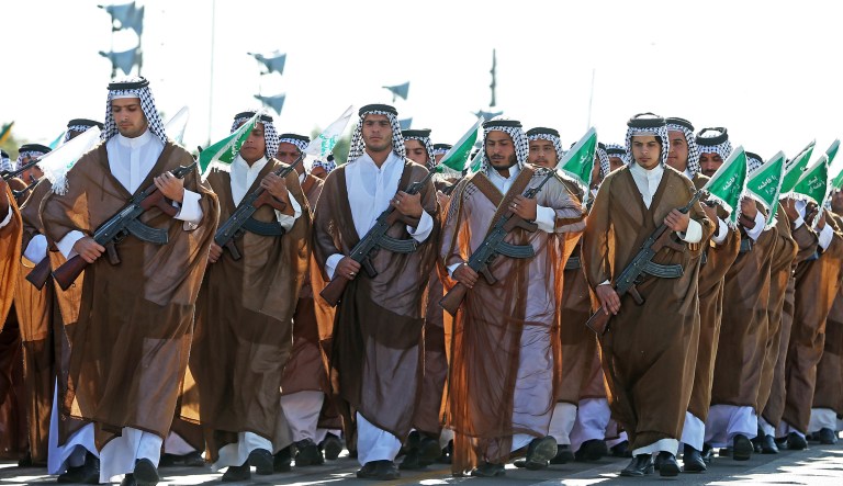 Iranian Arabs who are members of the paramilitary Basij force march in a military parade marking the 36th anniversary of Iraq's 1980 invasion of Iran, in front of the shrine of late revolutionary founder Ayatollah Khomeini, just outside Tehran, Iran, Wednesday, Sept. 21, 2016.