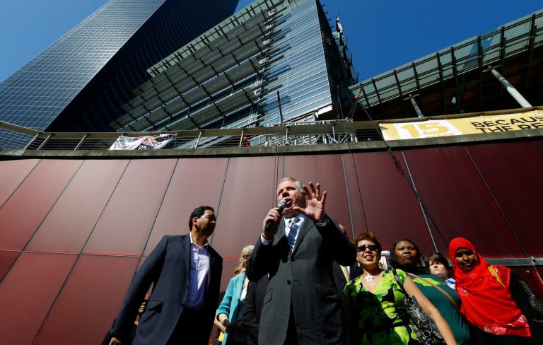 Seattle Mayor Ed Murray, center speaks Monday, June 2, 2014, at a rally outside Seattle City Hall after the Seattle City Council passed a $15 minimum wage measure. (AP Photo/Ted S. Warren)