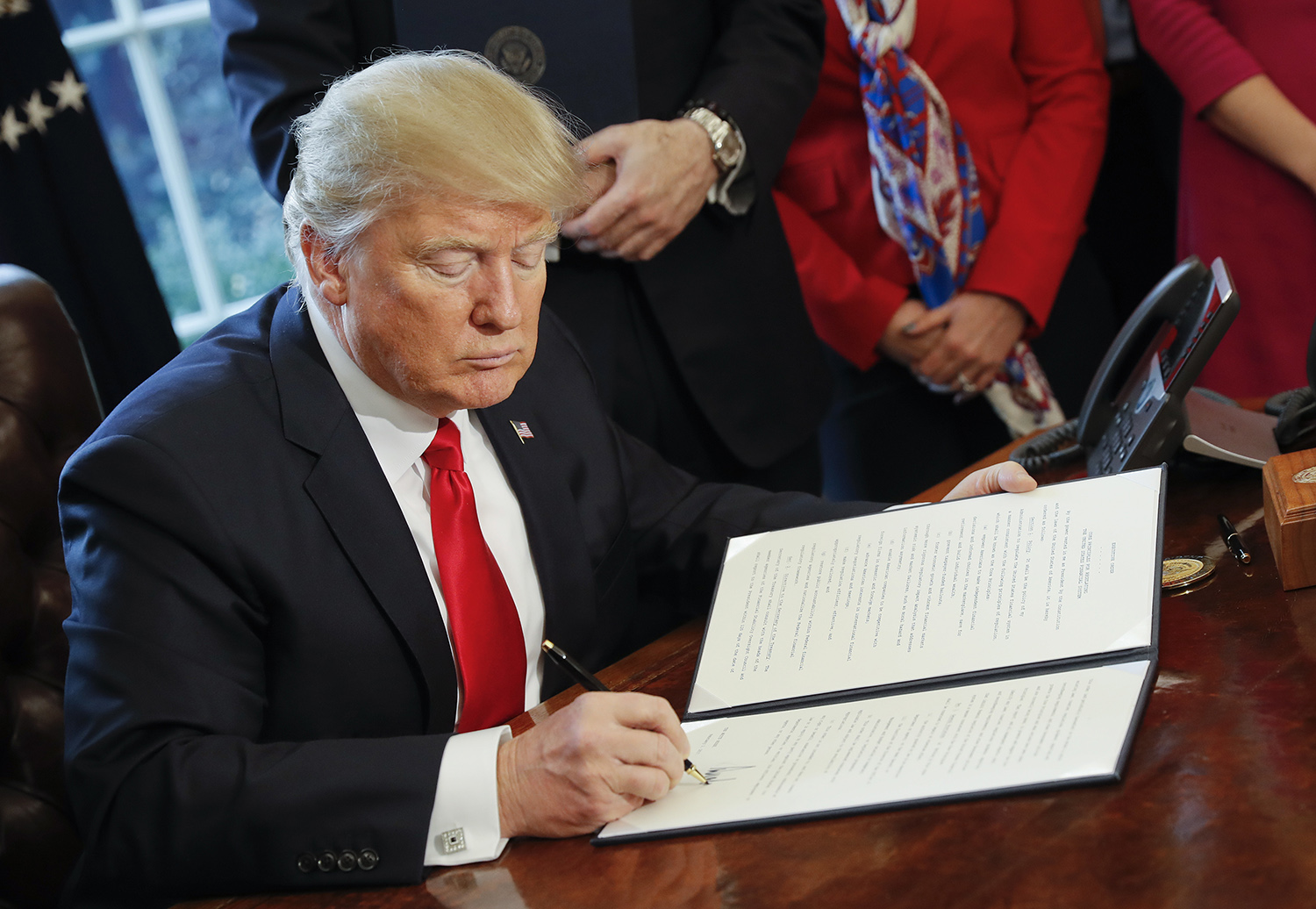 Trump signs new travel ban that excludes Iraqis, legal residents and visa holders