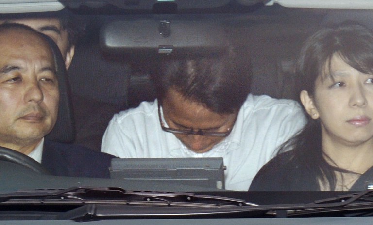   Katsuya Takahashi, center, a former Aum Shinrikyo cult member, is driven to Tokyo Metropolitan Police Department after being arrested, in Tokyo Friday, June 15, 2012. Police arrested Takahashi, 54, the last fugitive suspected in the doomsday cult's deadly nerve gas attack on Tokyo subways 17 years ago. He was spotted at a comic book cafe in downtown Tokyo earlier in the day. (AP Photo/Kyodo News) JAPAN OUT, MANDATORY CREDIT, NO LICENSING IN CHINA, HONG KONG, JAPAN, SOUTH KOREA AND FRANCE  