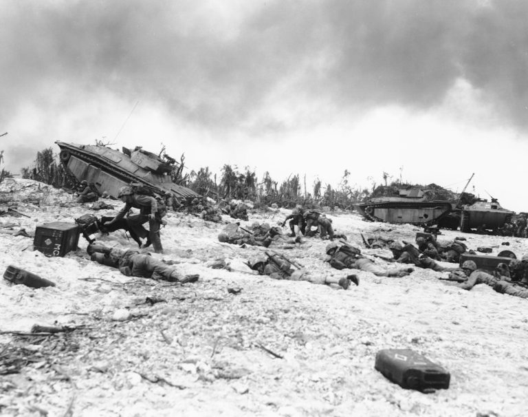 Supported by tanks, Marines of the 1st U.S. Division inch their way up on the beach of Peleliu, during the invasion of the island in the Palau group, on September 14, 1944. (AP Photo/Joe Rosenthal)