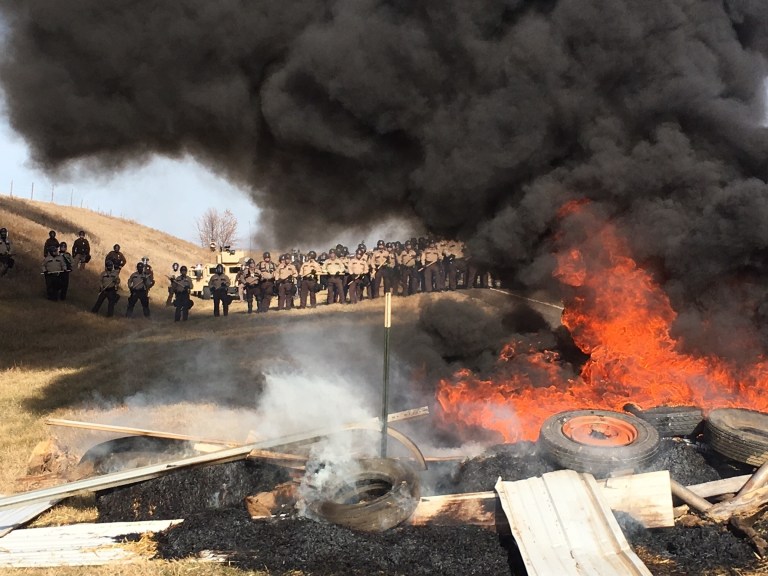 Dakota Access pipeline protesters in 2016 constructed barriers of tires and trees, which had been lit on fire, along with vehicles, according to Mother Jones reporter Wes Enzinna.