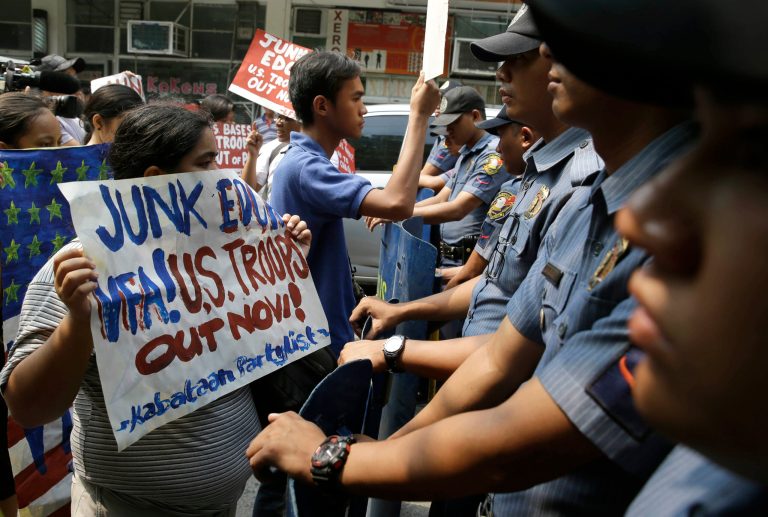Protesters are blocked by police as they attempt to hold a rally closer to the U.S. Embassy in Manila, Philippines Tuesday, May 27, 2014, to protest the recent agreement between the Philippine and U.S. militaries known as the Enhanced Defense Cooperation Agreement (EDCA). Civil society groups, including two former senators, who voted to reject the presence of U.S. military bases and its troops in 1991, filed a petition at the Supreme Court on Monday questioning the legality of the new security agreement, which was signed during the state visit by President Barack Obama in late April.  (AP Photo/Bullit Marquez)