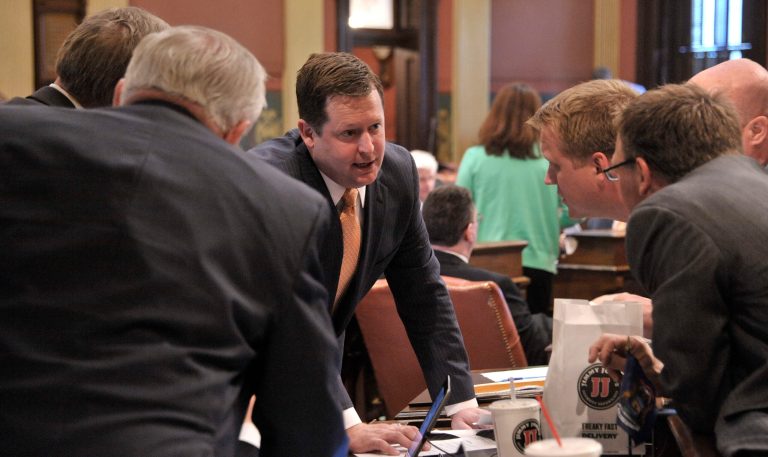 Speaker of the House Jase Boger, R-Marshall, talks over Detroit bailout bills with a huddle of Republicans Thursday, May 22, 2014 on the floor of the Michigan House of Representatives. The Michigan House has approved Detroit bankruptcy legislation that commits $195 million in state money to prevent deeper cuts in retiree pensions and the sale of city-owned art. The House voted 74-36 Thursday to spend money to match contributions from foundations and the Detroit Institute of Arts. Eleven bankruptcy-related bills cleared the Republican-led chamber and go to the Senate. (AP Photo/Detroit News, Dale G. Young)  DETROIT FREE PRESS OUT; HUFFINGTON POST OUT
