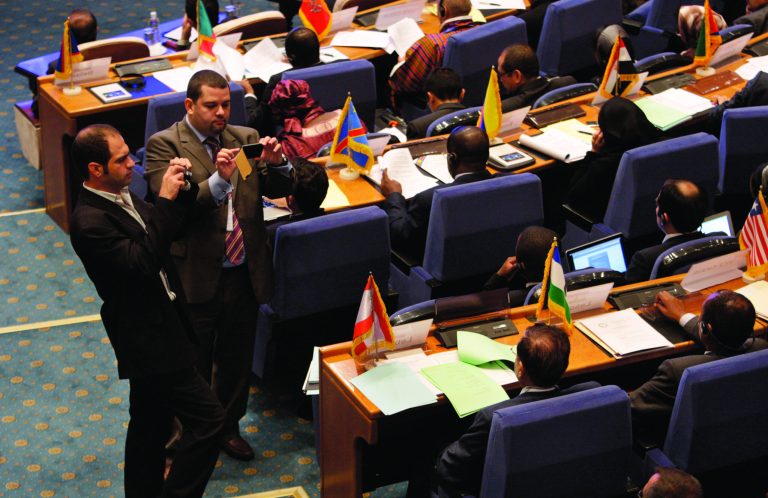 Two delegates take pictures of some participants of the Non-Aligned Movement ministers meeting in Tehran, Iran, Tuesday, Aug. 28, 2012. Iran is currently hosting a weeklong gathering of the 51-year-old movement, which ends Friday. (AP Photo/Vahid Salemi)