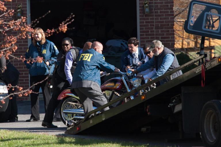 FBI and IRS agents help to push a motorcycle onto a tow truck outside the house of Councilman Harry Thomas Jr. in Northeast Washington on Dec 2, 2011.
