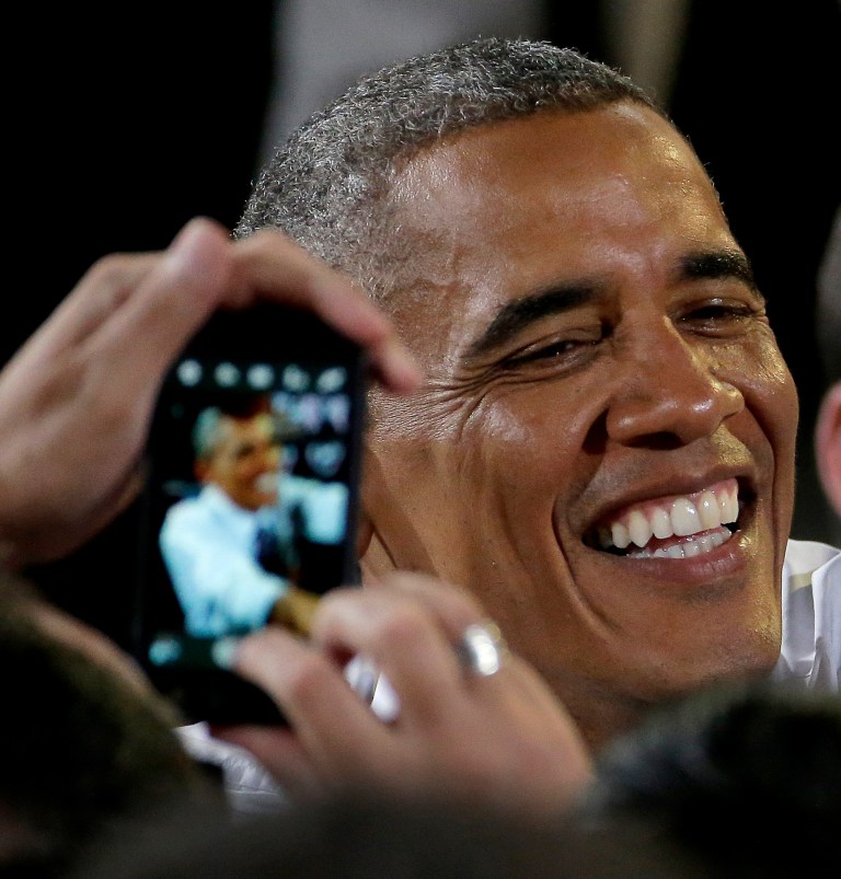 A guest uses their cellphone to photograph President Barack Obama as greets the crowd after speaking about the economy, Wednesday, July 30, 2014, at the Uptown Theater in Kansas City, Mo. (AP Photo/Charlie Riedel)