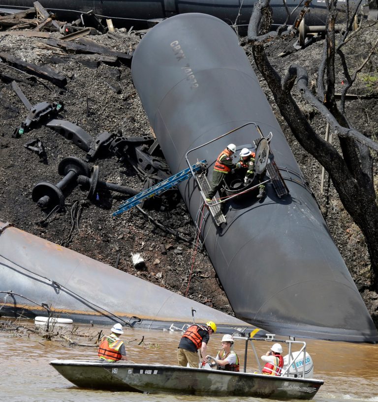 FILE - This May 1, 2014 file photo shows the site where several CSX tanker cars carrying crude oil derailed and caught fire along the James River near downtown Lynchburg, Va. U.S. Railroads forced to turn over details on crude oil shipments are asking states to sign agreements not to disclose the information but some officials are refusing, saying it should be public. Federal officials last month ordered railroads to make the disclosures following a string of fiery tank car accidents in North Dakota, Alabama, Virginia, Quebec and elsewhere. (AP Photo/Steve Helber, file)