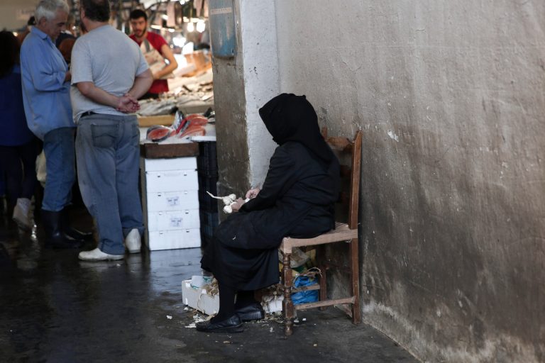 An woman sells garlic at a central Athens' Fish market Thursday, Oct. 16, 2014.   Greece is back at the center of Europe's financial troubles, with concerns over the stability of the government and its bailout program triggering a massive sell-off in stocks this week, falling 1.6 percent in early afternoon trading Thursday.(AP Photo/Petros Giannakouris)
