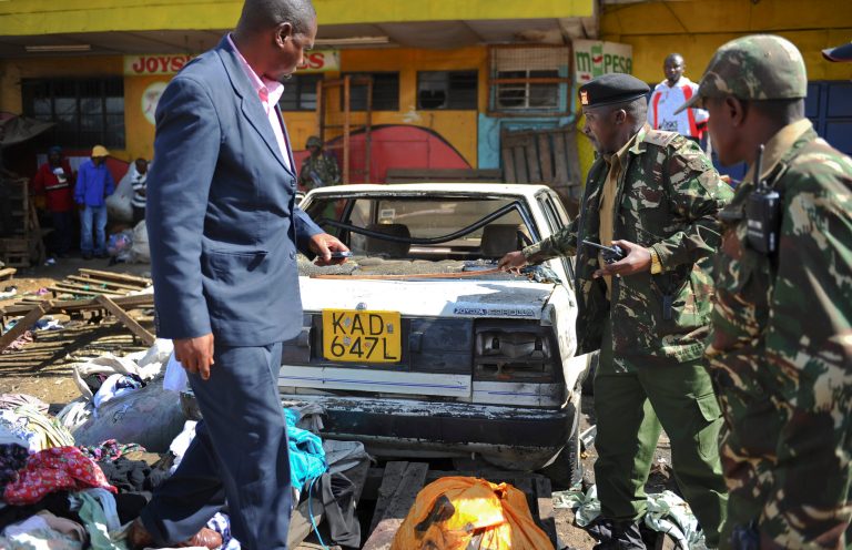 FILE - In this Friday, May 16, 2014 file photo, security forces inspect the scene at the site where two blasts detonated, one in a mini-van used for public transportation, in a market area of Nairobi, Kenya. Officials and analysts in Kenya say that corrupt police and other government employees willing to break rules for bribes are weakening Kenya's ability to prevent a new rash of terror carried out by attackers with links to Somali militants, which has seen a long string of deadly attacks this year, including grenade blasts and homemade bombs. (AP Photo, File)