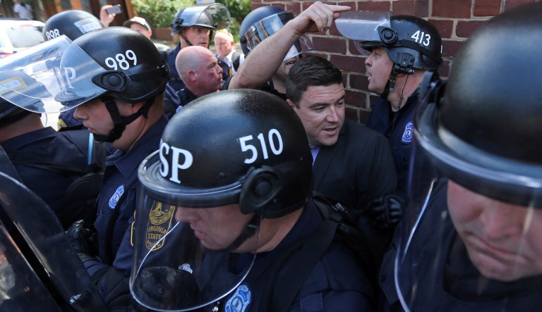 Unite the Right rally organizer Jason Kessler is escorted by police after his press conference was disrupted by protestors Sunday, Aug. 13, 2017, outside City Hall in Charlottesville, Va. (Andrew Shurtleff /The Daily Progress via AP)