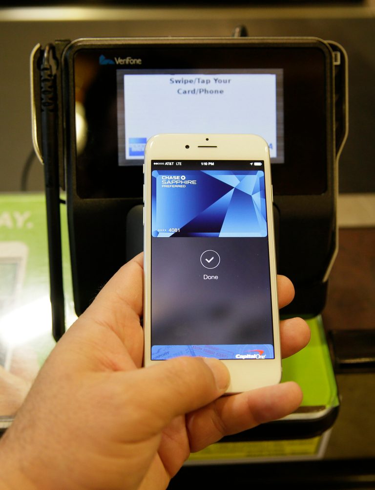 In this photo taken Friday, Oct. 17, 2014, Eddy Cue, Apple Senior Vice President of Internet Software and Services, demonstrates the new Apple Pay mobile payment system at a Whole Foods store in Cupertino, Calif. The new system launches on Monday. (AP Photo/Eric Risberg)