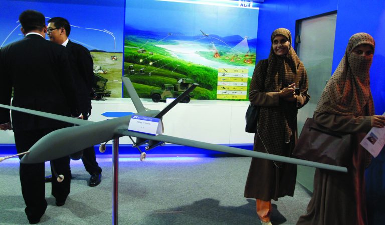 In this Thursday, Nov. 15, 2012 photo, visitors look at Pakistan-made unmanned aircraft at defense exhibition in Karachi, Pakistan. Pakistan is secretly racing to develop its own armed drones, frustrated with U.S. refusals to provide the aircraft, but is struggling in its initial tests with a lack of precision munitions and advanced targeting technology. The development of unmanned combat aircraft is especially sensitive in Pakistan because of the widespread unpopularity of U.S. drone strikes against militants in the rugged tribal region bordering Afghanistan. (AP Photo/Shakil Adil)