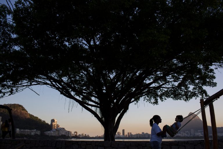In this Aug. 7, 2014 photo, a nanny pushes a boy on a swing in Rio de Janeiro, Brazil. A new law fining employers who fail to register their domestic workers is the Brazilian government's latest effort to extend the country's generous labor laws to its around 6 million maids, nannies and other home-care providers. (AP Photo/Felipe Dana)
