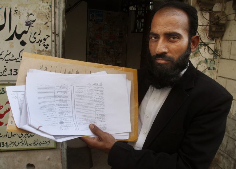 Mustafa Kharal, lawyer of  pregnant woman Farzana Parveen who was stoned to death, shows her marriage certificate in Lahore, Pakistan, Wednesday, May 28, 2014.  Nearly 20 members of the woman's family, including her father and brothers, attacked her and her husband with batons and bricks in broad daylight before a crowd of onlookers in front of the high court of Lahore, police investigator Rana Mujahid said. (AP Photo/K.M. Chaudary)