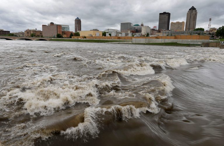 Water splashes over the Center Street Dam in the swollen Des Moines River in downtown Des Moines, Iowa. (AP/Charlie Neibergall)