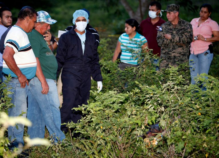 Forensic workers, relatives and law enforcement officials stand next to the site where the body of TV reporter Herlyn Espinal was found in in San Pedro Sula, Honduras, Monday, July 21, 2014. Espinal was 32 and worked for a news program on Channel 3 television in San Pedro Sula, long considered the most violent city in Honduras, which in turn is the country with the highest murder rate in the world: 90.4 per 100,000 inhabitants. (AP Photo)