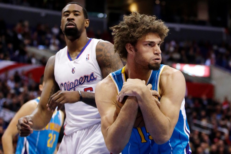   New Orleans Hornets center Robin Lopez, right, pulls in a rebound as Los Angeles Clippers' DeAndre Jordan watches during the first half of an NBA basketball game in Los Angeles, Wednesday, Dec. 19, 2012. (AP Photo/Chris Carlson)  