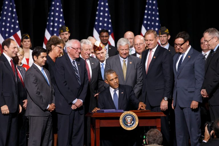 President Barack Obama signs into law the Veterans Access, Choice, and Accountability Act of 2014, a bill providing the Department of Veterans Affairs the resources to improve access and quality of care for veterans, Thursday, Aug. 7, 2014, at Fort Belvoir, Va. (AP Photo/J. Scott Applewhite)