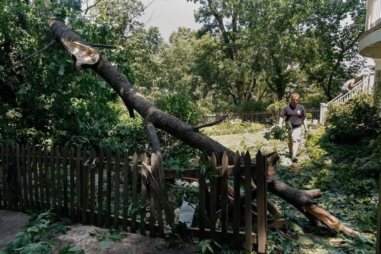 Kyle Hartic of Alexandria cleans up after the storm, which caused massive damage and knocked out 911 phone lines. (Graeme Jennings/Examiner)