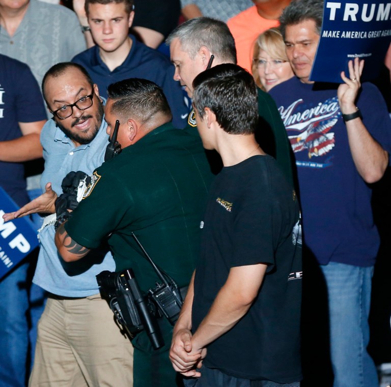 A protester is removed from a Republican presidential candidate Donald Trump campaign rally in Boca Raton, Fla., Sunday, March 13, 2016. (AP Photo/Paul Sancya)