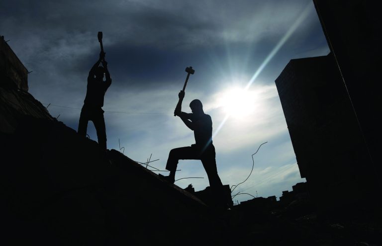 Syrian men use sledgehammers to break the concrete of a residential building destroyed in a government airstrike, while searching for belongings under the rubble, in Maaret Misreen, near Idlib, Syria, Wednesday, Dec. 12, 2012. (AP Photo/Muhammed Muheisen)