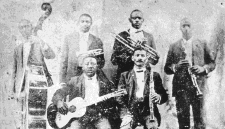 Buddy Bolden's band is pictured. Bolden is the man second to the left at the top row.